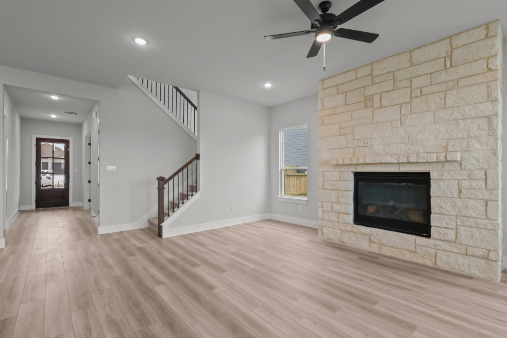 A room with a fireplace and a wood floor.