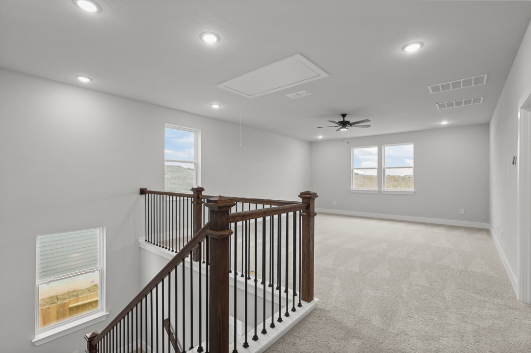A room with a railing and a staircase.