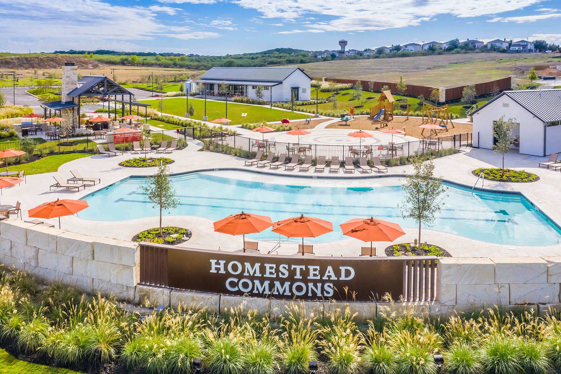 A pool with umbrellas and chairs by it.