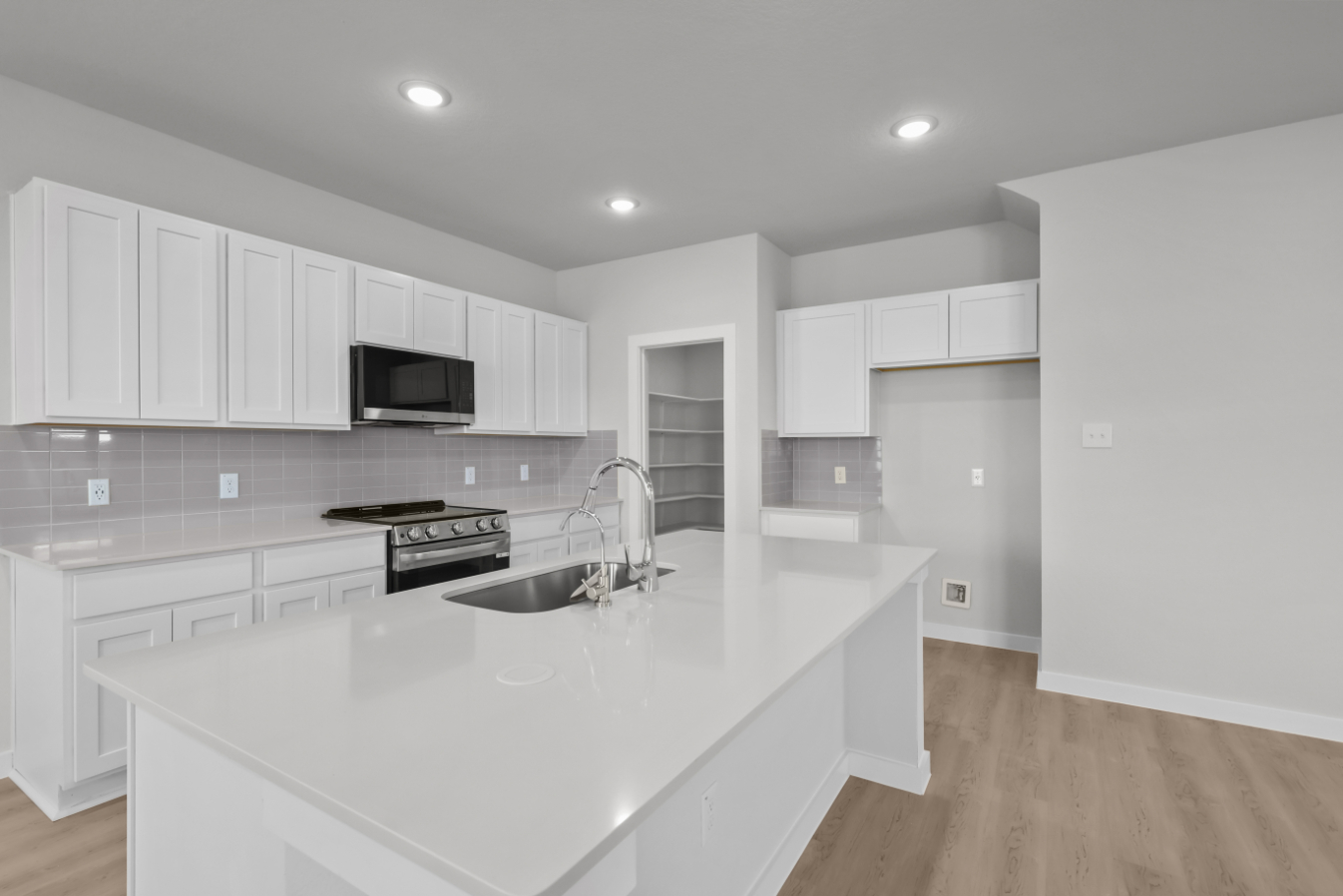 A kitchen with white cabinets.