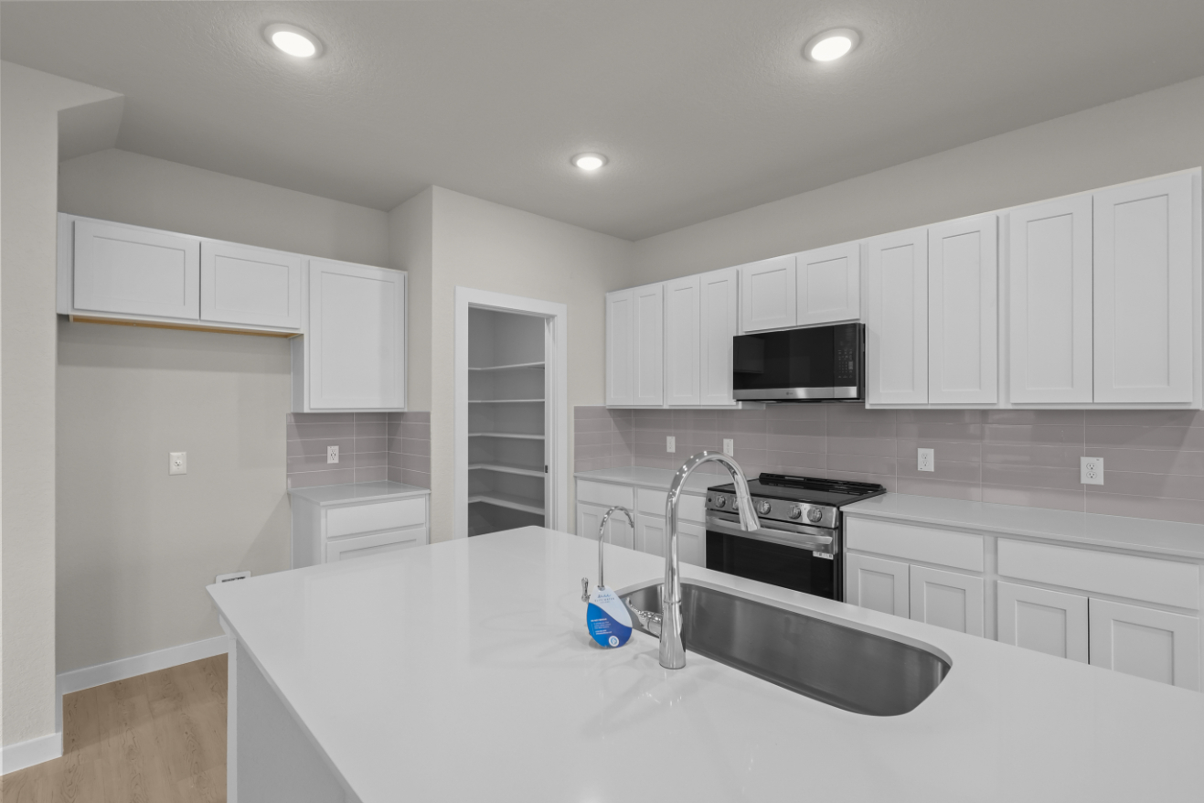 A kitchen with white cabinets.