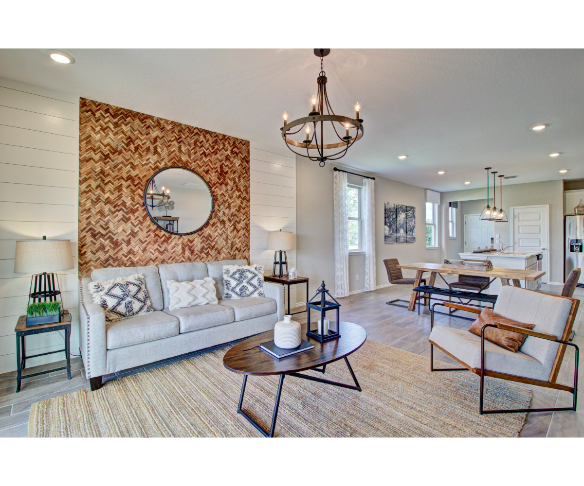 A living room with a large stone wall and a large round mirror.