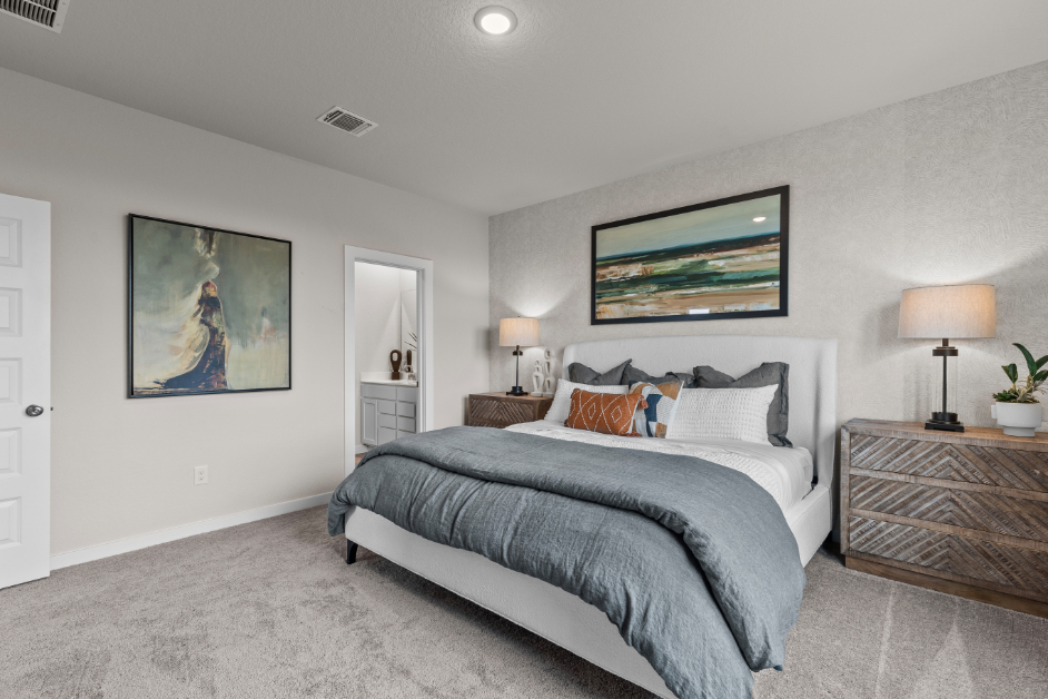 A bedroom with a bed and lamps.