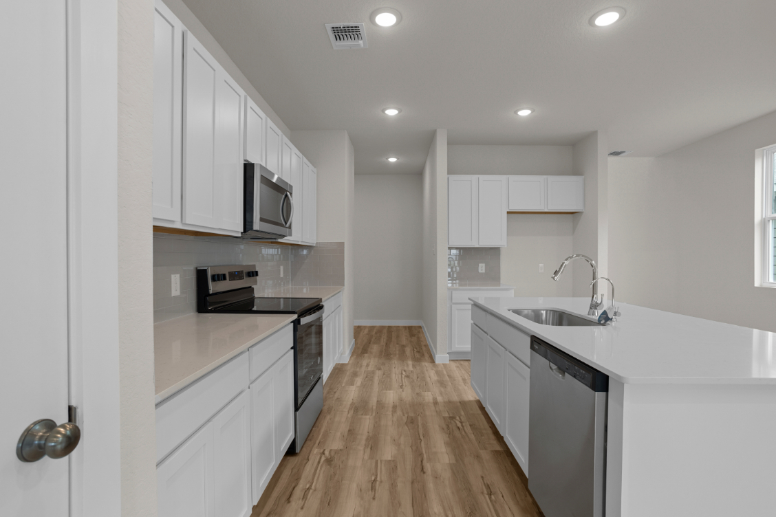 A kitchen with white cabinets.