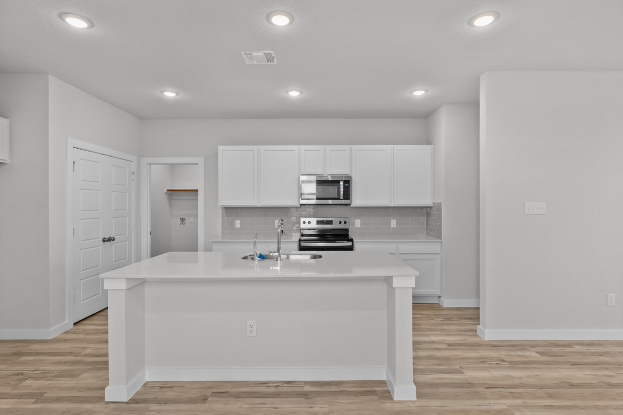 A kitchen with white cabinets.