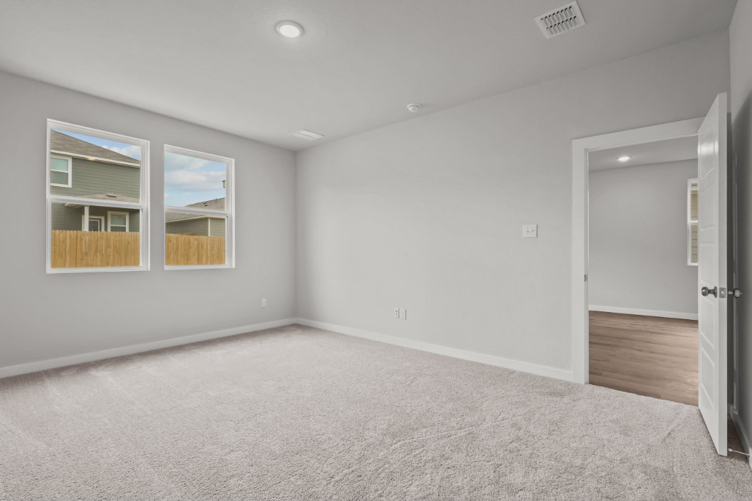 A room with a carpet and a window.