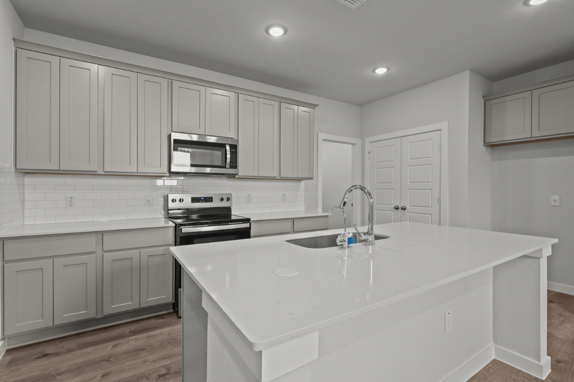 A kitchen with white cabinets.