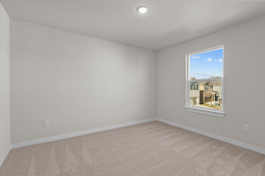 A room with a window and a carpet.