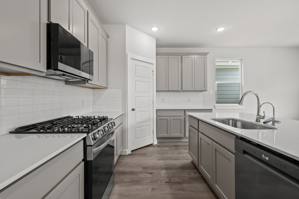 A kitchen with white cabinets.
