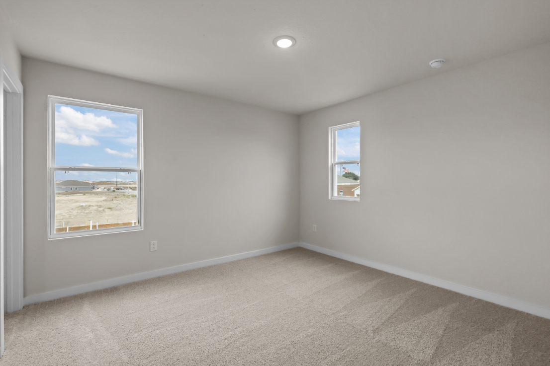A room with a window and a carpet.