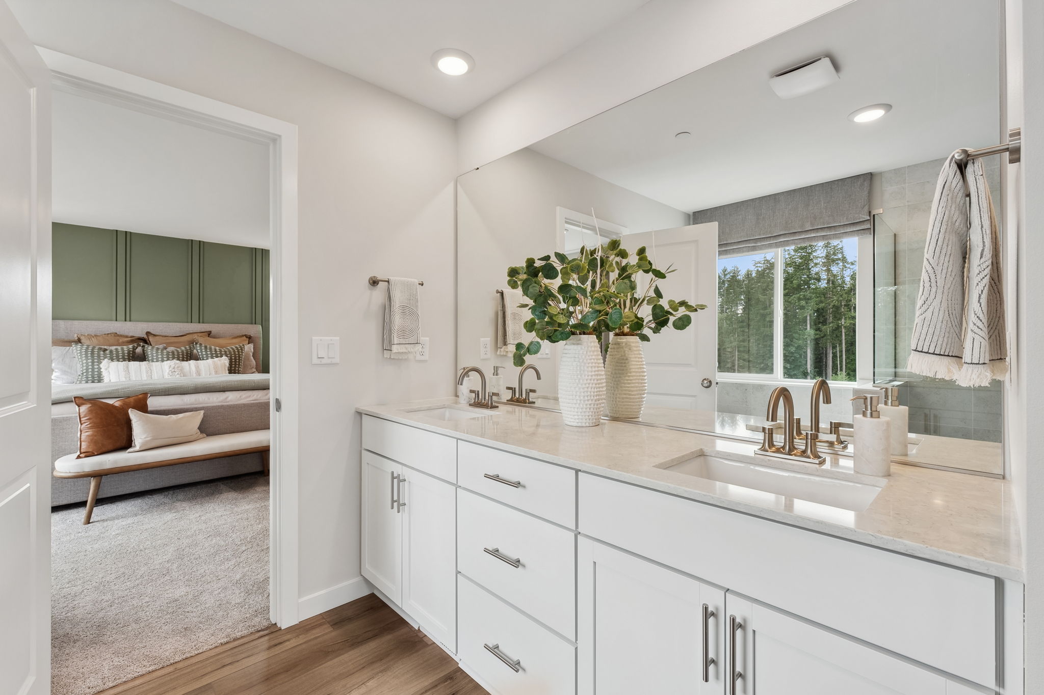 A bathroom with a tub sink and a bed.