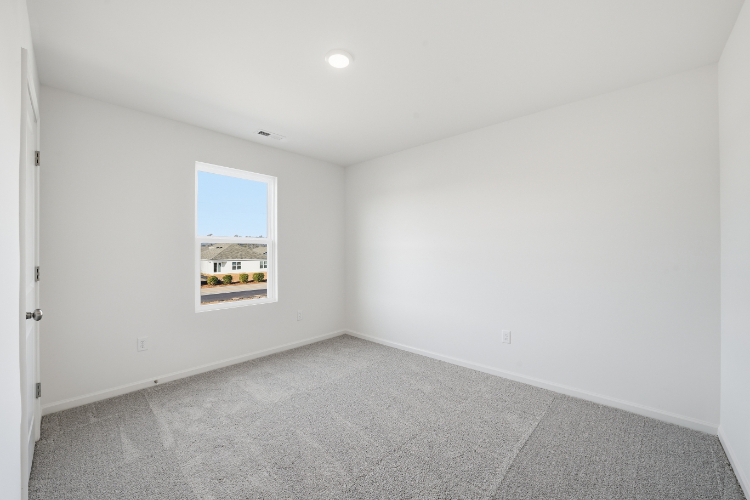 A room with a window and a carpet.