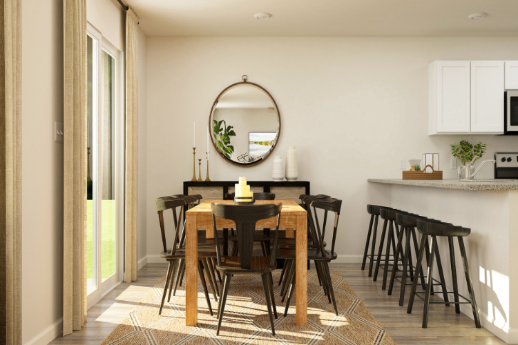 A dining room with a round mirror.