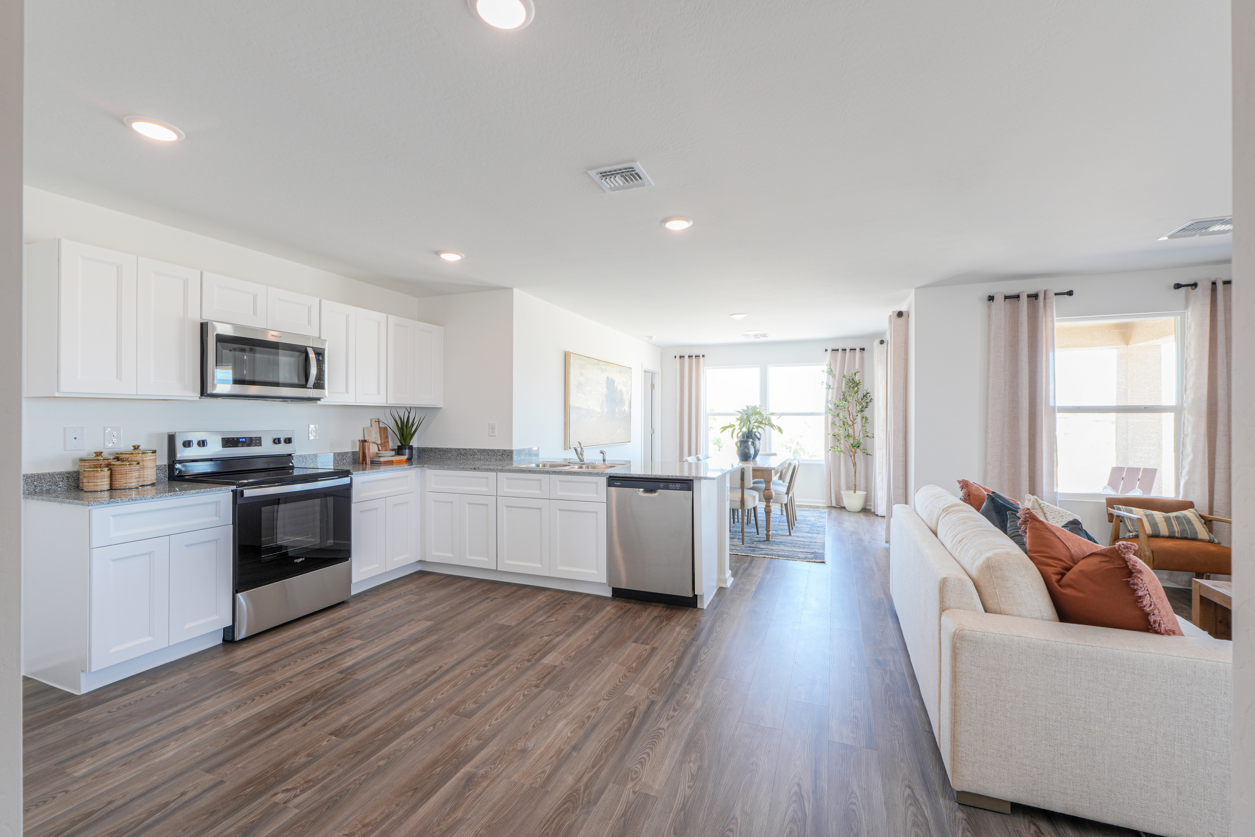 A large kitchen with a wood floor.