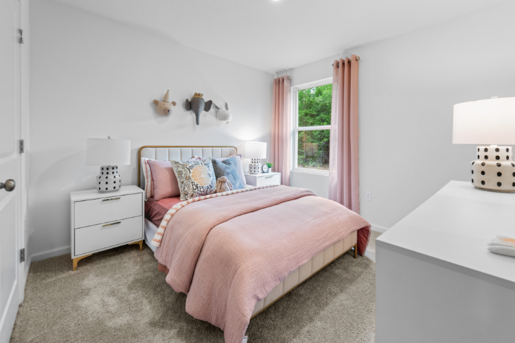 A bedroom with a pink bed.