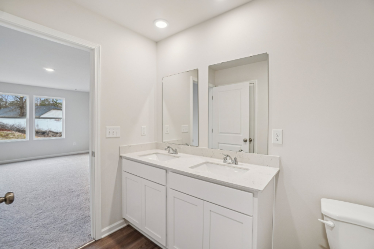 A bathroom with white cabinets.