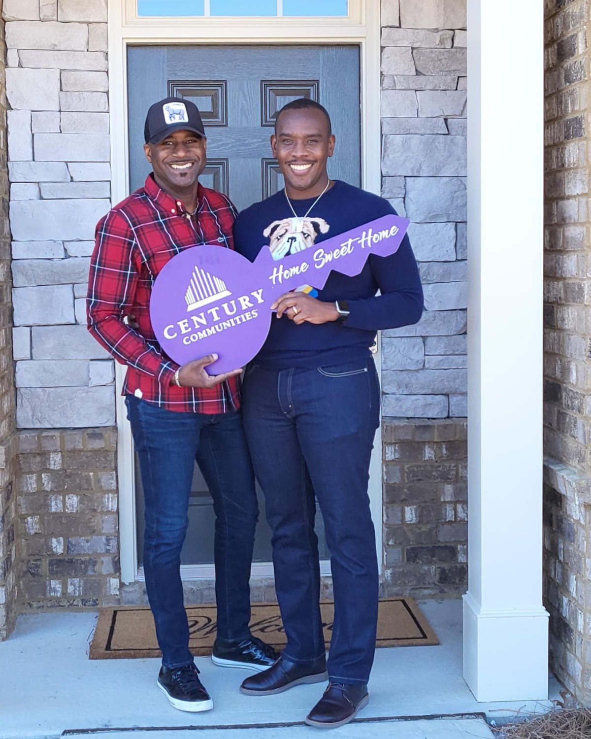 Two men holding a purple sign.
